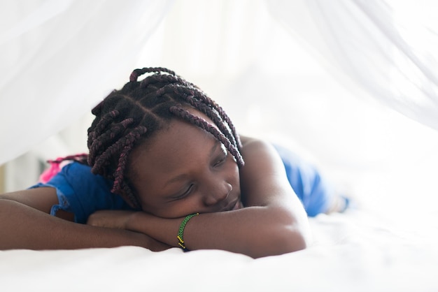 Young beautiful black girl awaking in bedroom bed