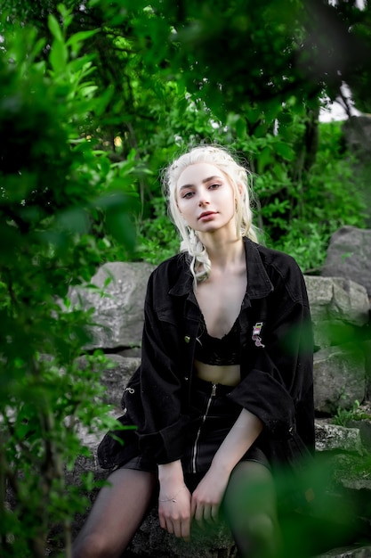 Young beautiful blonde girl in a black denim jacket nature