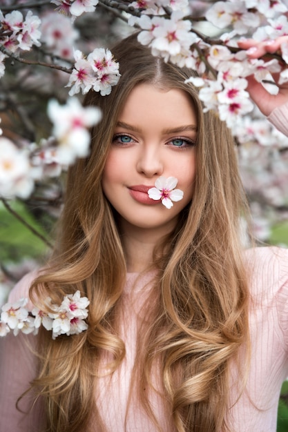 Young beautiful blonde woman in a blooming garden