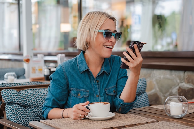 Young beautiful blonde woman on a summer morning in sunglasses