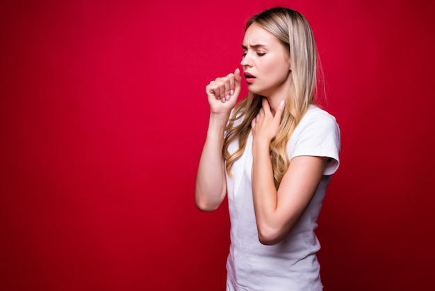 Young beautiful blonde woman wearing casual sweater over red isolated wall feeling unwell and coughing as symptom for cold or bronchitis. Health care concept.