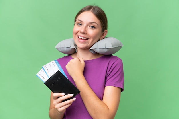 Young beautiful blonde woman with Inflatable travel Pillow over isolated background celebrating a victory