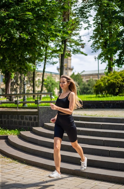 A young beautiful blonde woman with a sporty physique in a black T-shirt 