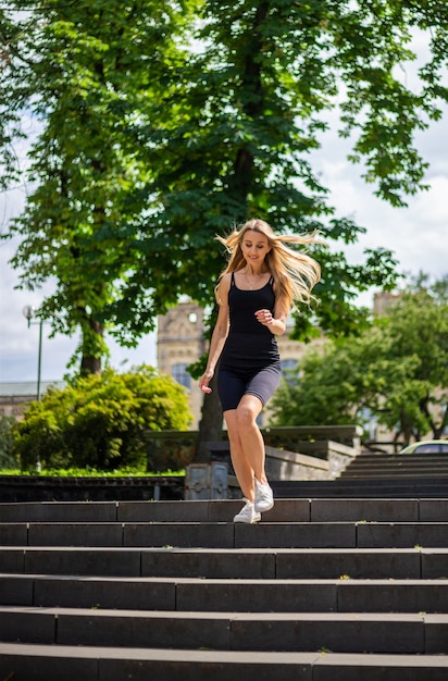 A young beautiful blonde woman with a sporty physique in a black T-shirt 