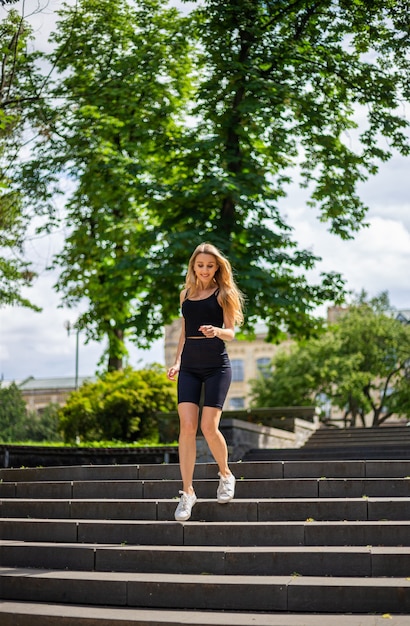 A young beautiful blonde woman with a sporty physique in a black T-shirt 