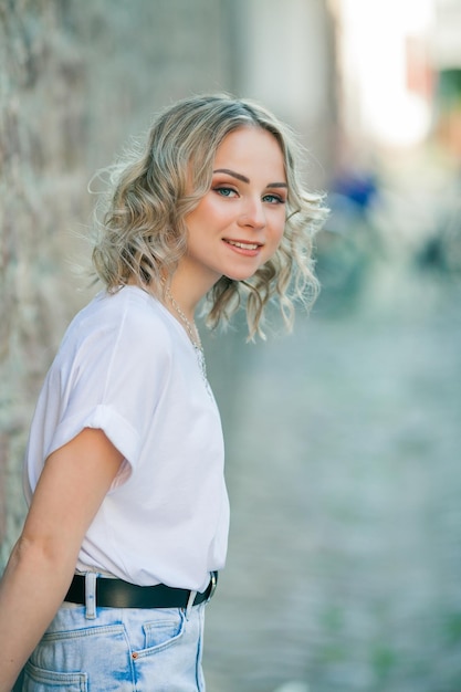 Young beautiful blueeyed blonde in the center of a European city Portrait of a stylish model in casual clothes Happy youth