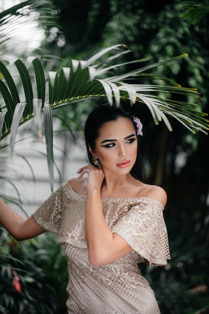 A young beautiful brunette posing among dense thickets of jungle and rainforest. Spa.