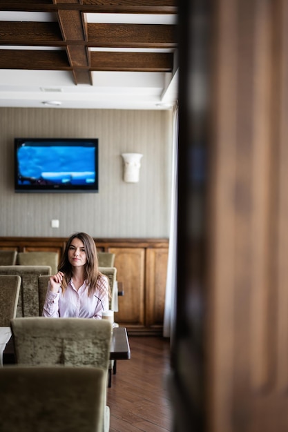 Young beautiful brunette woman sit in coffee shop cafe restaurant indoors