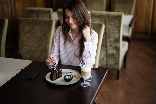 Young beautiful brunette woman sit in coffee shop cafe restaurant indoors