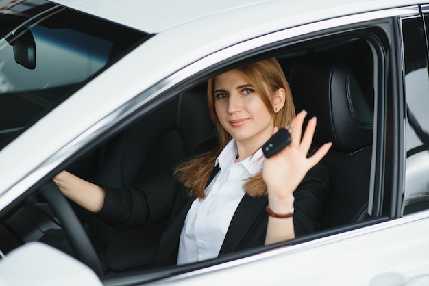 Young beautiful business woman sitting in her car