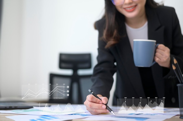 Young beautiful business woman working on laptop with documents in modern office