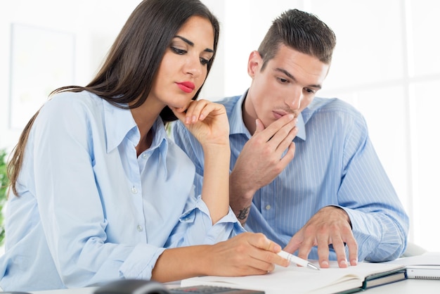 Young beautiful businesswoman and businessman working in the office.