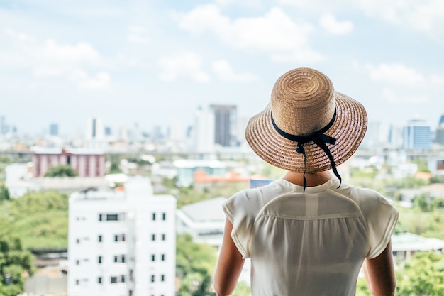 Young beautiful caucasian woman looking at the city from the heights