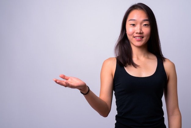  young beautiful Chinese woman against white wall