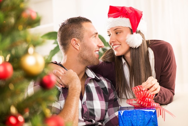 Young beautiful couple exchanging a Christmas gifts.