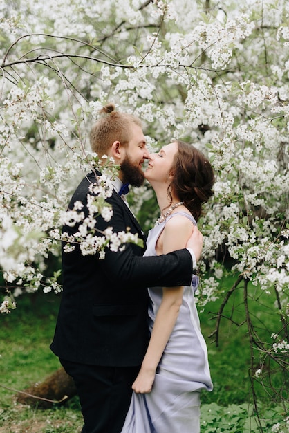 Young beautiful couple in the garden against the background of cherry blossoms 1