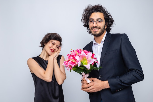 Young beautiful couple happy man giving a bouquet of flowers to his lovely girlfriend happy in love celebrating valentine