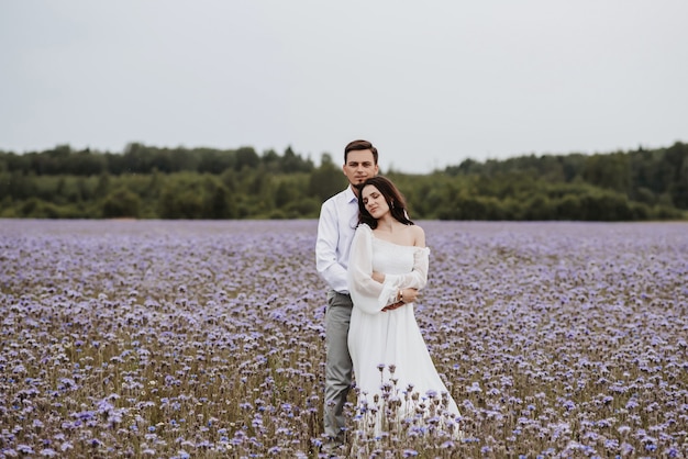 Young beautiful couple hugging in a blooming purple field