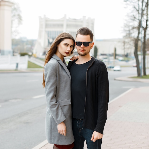 Young beautiful couple in jeans clothes and coat on the street