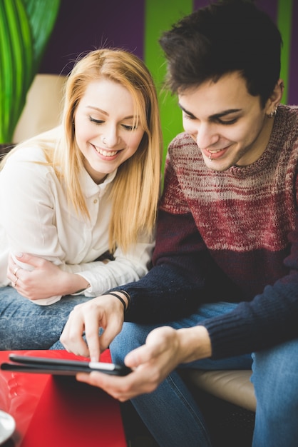 young beautiful couple lovers sitting at the bar using wireless tablet connected online