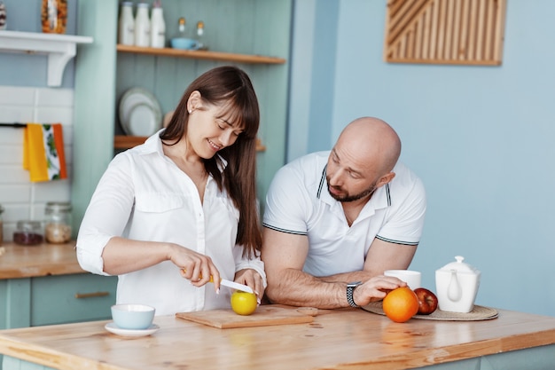 A young beautiful couple prepares Breakfast together in the kitchen on a weekend morning