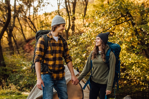 Young beautiful couple with hiking backpacks go hiking