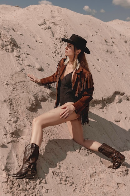 Young beautiful cowgirl posing in desert.