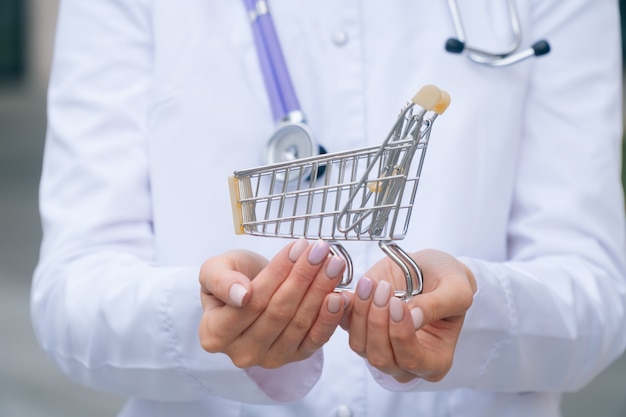 Young beautiful doctor with a shopping cart