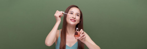 young beautiful female applying facial serum