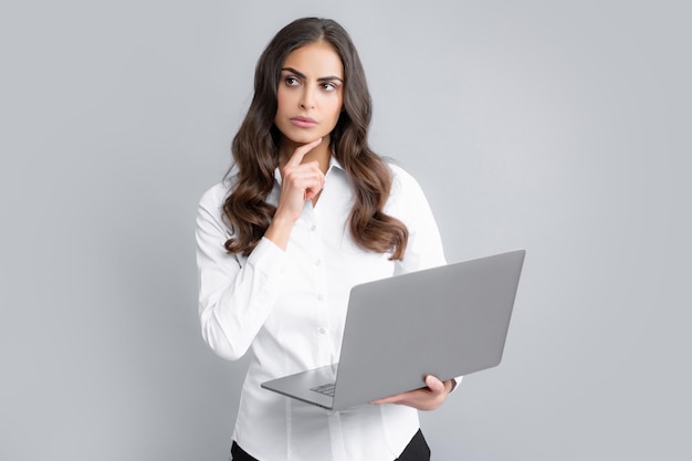 Young beautiful female teacher or happy student isolated on gray studio background Portrait of college student with laptop Woman working on laptop freelance