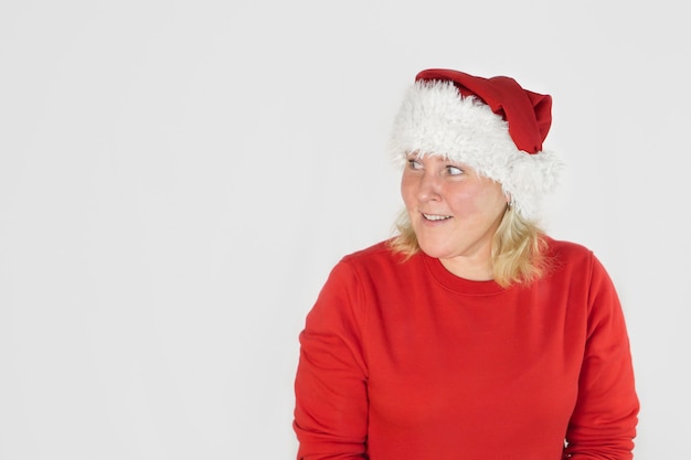 Young beautiful girl in Christmas Santa hat on isolated white background with happy face standing and smiling with confident smile showing teeth