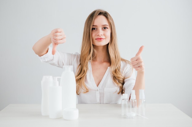 Young beautiful girl compares the size of cosmetic bottles for travel to save space in the suitcase. Toning.