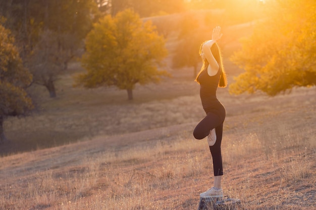 Young beautiful girl doing yoga in nature