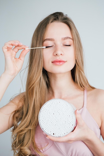 Young beautiful girl holding a jar of useful bamboo cotton buds. The concept of plastic free and zero waste. Toning.