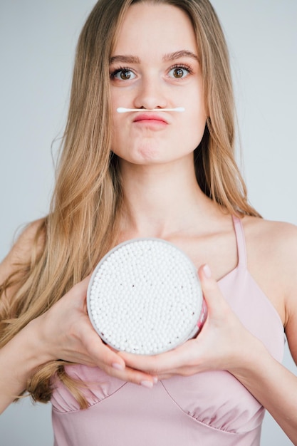 Young beautiful girl holding a jar of useful bamboo cotton buds. The concept of plastic free and zero waste. Toning.