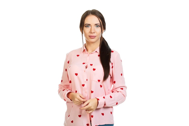 Young beautiful girl iin a pink shirt with red hearts on a white background