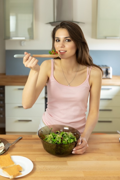 Young beautiful girl is preparing healthy organic food for breakfast.