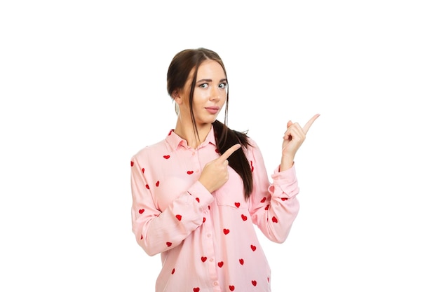 Young beautiful girl isolated on a white background points his fingers at the place for promo offers or advertising