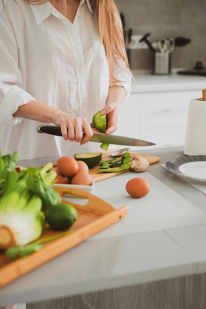 Young Beautiful girl in the kitchen prepares healthy food Close up of female hands