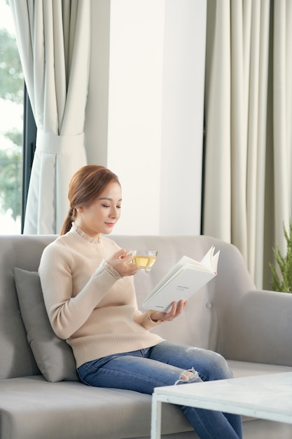 Young beautiful girl reading a book. Relaxed on a leisure day at home