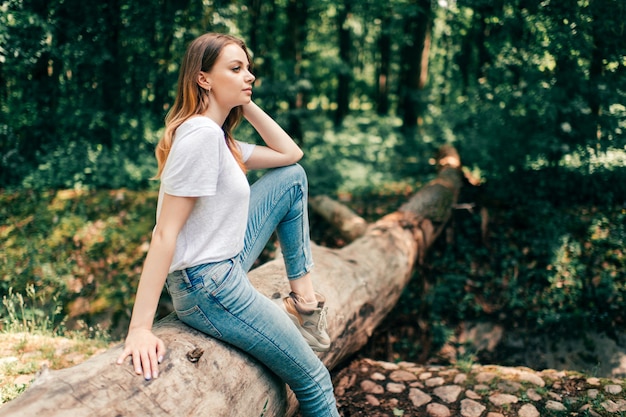 Young beautiful girl sitting on the tree