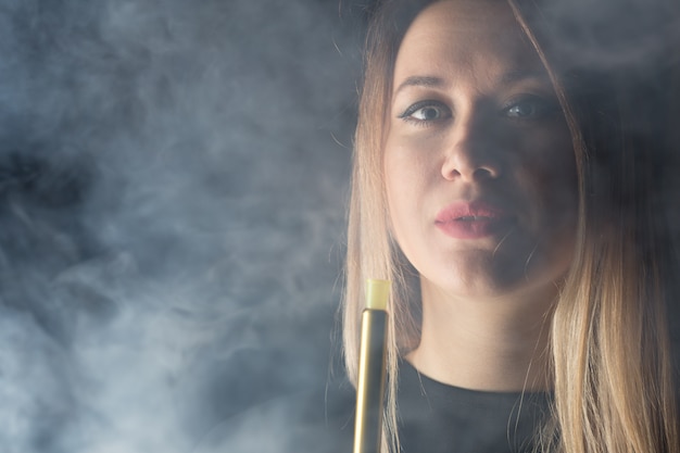 Photo young, beautiful girl smokes a hookah