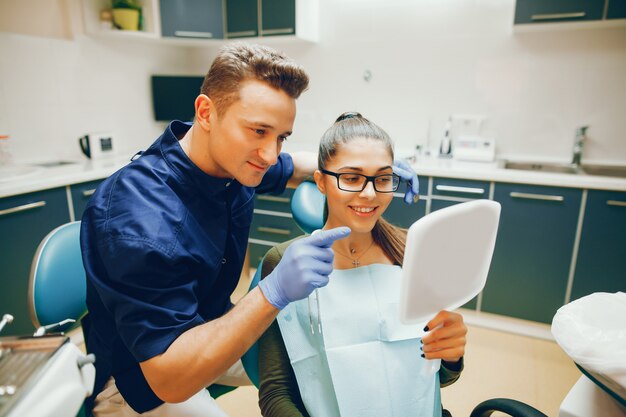 A young and beautiful girl treats her teeth with a dentist