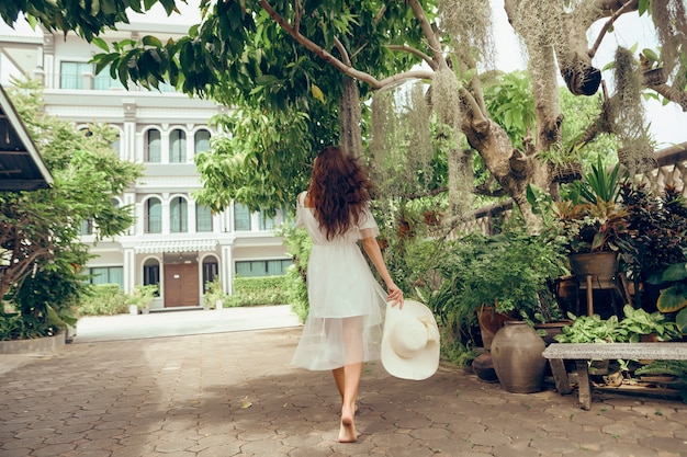 young beautiful girl in a white dress walking