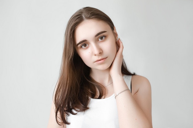 Young beautiful girl with clean skin Women without wrinkles on the face closeup on a gray background