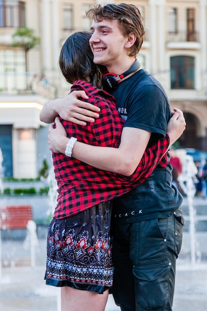 Young beautiful girl with a guy dancing in a fountain