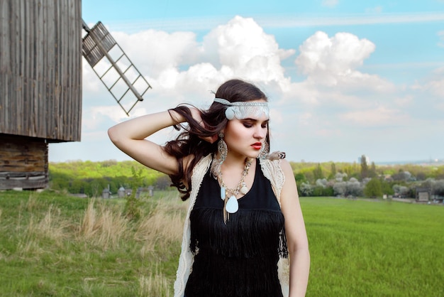 Young beautiful girl with long dark hair in green field in outdoor ethnic village in Kyiv Ukraine