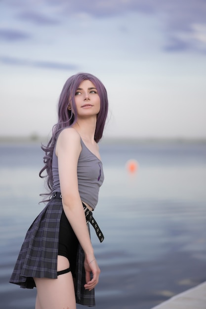 Young beautiful girl with purple hair on a background of clouds