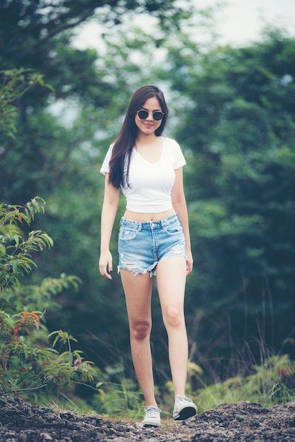 young beautiful girl woman happy with nature, against background of mountain and forest