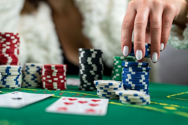 Young beautiful girl won in poker and takes all the chips with her own hands